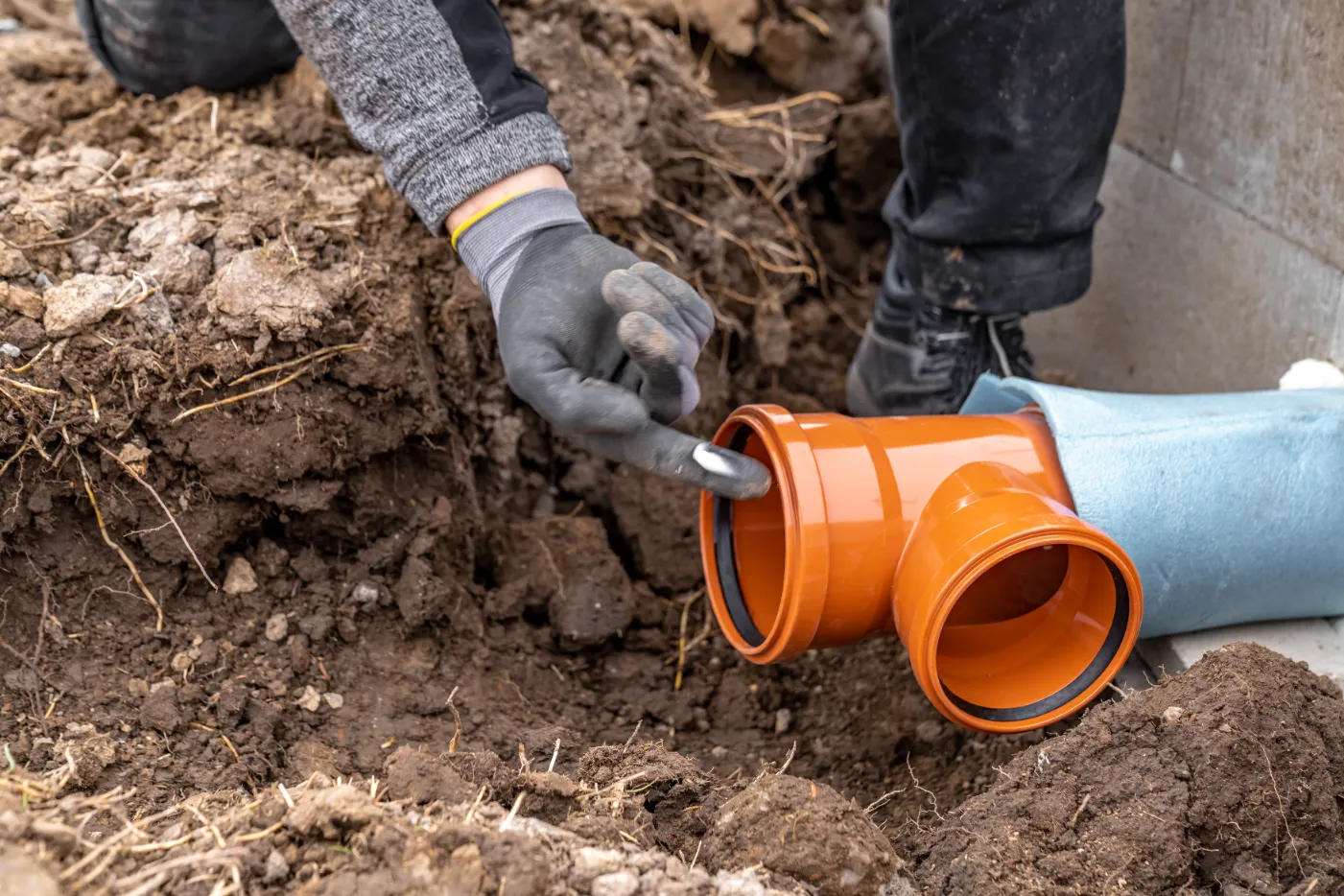 PVC pipe installed underground by a worker.