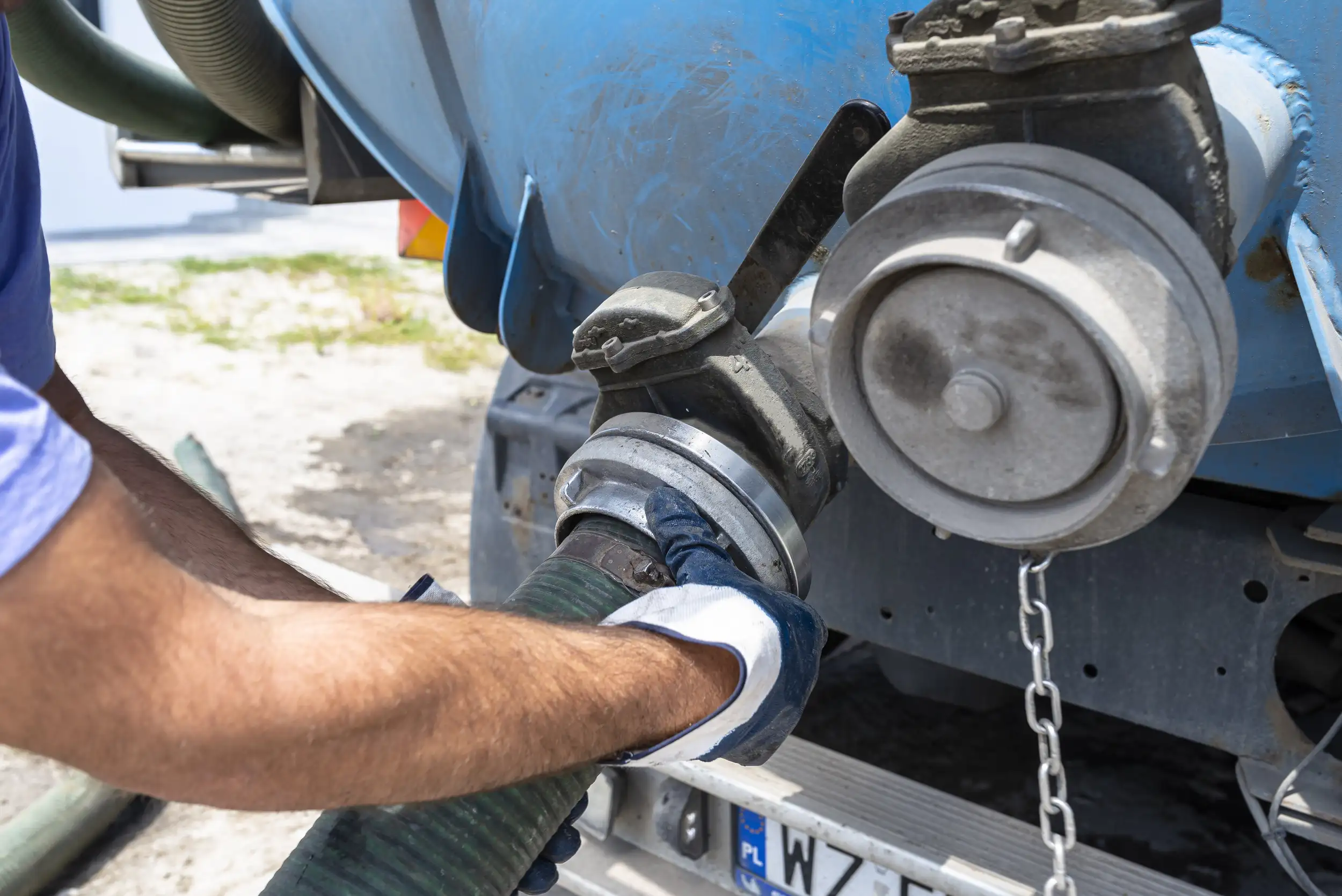 A man tightening the pump on the truck.